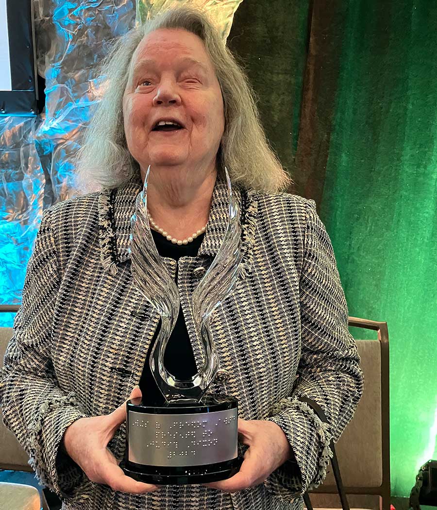 Photo of Judy holding crystal award.